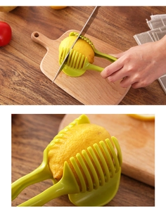 Handheld green slicer holder for lemon and tomato on a wooden cutting board