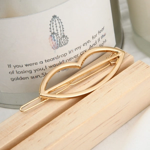 Golden lip-shaped hair clip with S925 mark on a minimalist wooden base