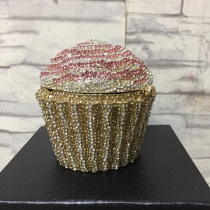Macro detail of cupcake clutch bag showing pink crystals and gold hollow metal frame