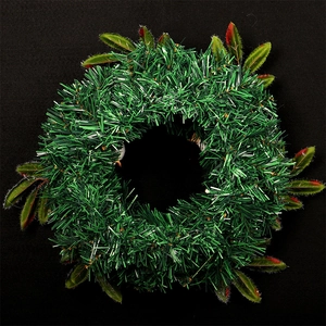 Couronne de Noël traditionnelle en guirlande verte avec feuilles à pointes rouges