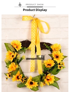Détail d'une couronne de tournesols en forme de cœur avec base en vigne et ruban à pois
