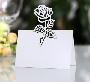 Macro view of laser-cut white paper rose place card for elegant wedding table setting