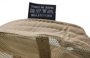 Detailed close-up of 100% cotton wash label and neat stitching on beige mesh cap