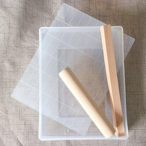 Close-up of 4-piece snowflake cake mold set with wood rolling pin and plastic tray
