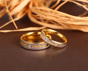 Macro shot of two-tone gold and silver brushed steel rings with forever love engraving