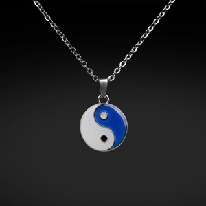 Macro detail of Tai Chi pendant with temperature-sensing color-changing effect on steel chain