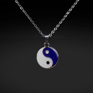 Macro detail of Yin Yang Tai Chi pendant in blue and white on a silver link chain