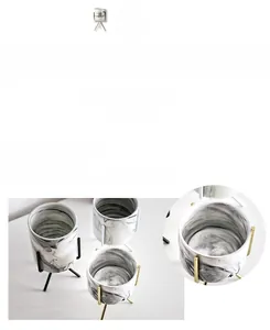 Detailed view of the irregular marble ink texture on a ceramic flower pot with gold stand