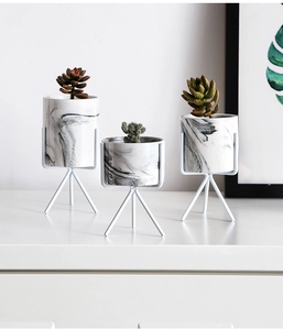 Three-piece marble pattern ceramic planters with white metal tripod stands and succulents