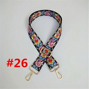 Detail of adjustable ethnic style bag strap with colorful floral patterns and gold hooks