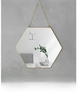 Detalle de espejo hexagonal de latón con marco dorado y diseño de arte lineal moderno