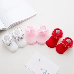 Three pairs of lace-trimmed baby socks with polka dot bows in white, pink, and red