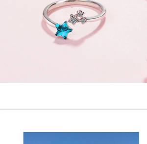 Close-up of a silver open ring featuring a blue star crystal and small clear stones