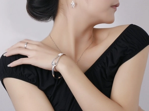 Detailed close-up of a silver rose flower open bangle and matching minimalist jewelry set