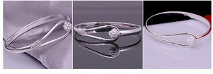 Detailed macro view of silver flower bracelet featuring a 3D rose and wire-wrapped design