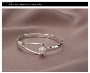 Close-up of silver open cuff bracelet featuring 925 stamp and a 3D rose flower design
