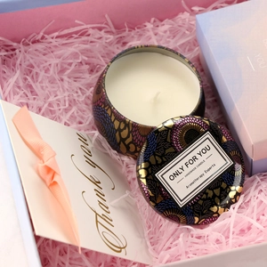 Handmade scented soy candle in colorful tin with ethnic pattern gift box and pink filler