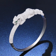 Detailed macro view of a silver cheetah bracelet with white zircon and emerald eye detail