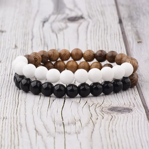 Close-up of black agate and white matte beads with natural wood grain bracelets