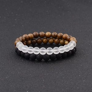 Detail of beaded bracelet set with wood grain, black lava rock and white matte stone beads