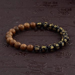 Close-up of wooden grain beads and black obsidian prayer beads with gold mantras