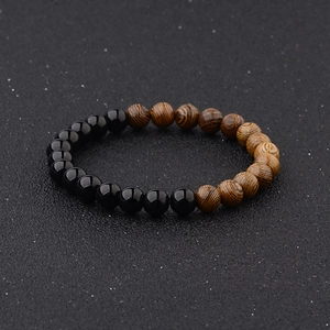 Close-up of beaded bracelet featuring black glossy beads and natural wood grain textures