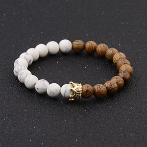 Close-up of wood and white stone beaded bracelet with a gold crown charm centerpiece