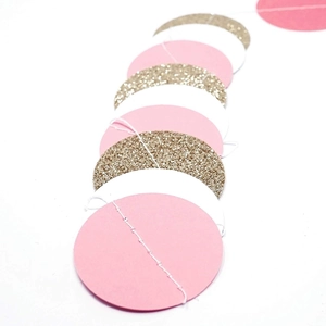 Close-up of pink and gold glitter circle and moon paper garland for party decorations