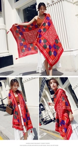 Detail of red Bohemian cotton linen shawl with geometric floral patterns and fringe