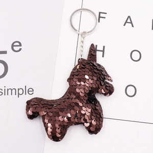 Detail of a brown sequin unicorn keychain with a polished metal ring and chain