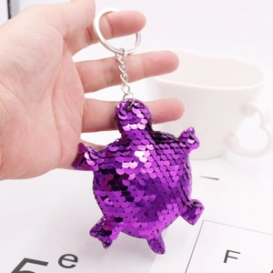 Detailed view of a purple sequin turtle keychain with a silver metal ring and chain