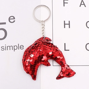 Macro shot of red dolphin sequin keychain with shiny silver metal ring and link chain