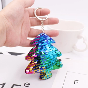 Close-up of rainbow sequin Christmas tree keychain with metallic ring held in hand