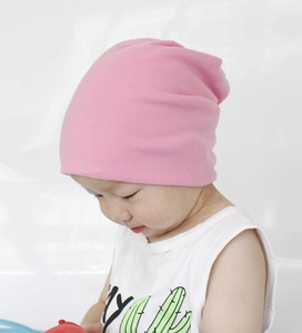 Close-up of baby girl wearing pink soft cotton knit beanie hat for winter warmth