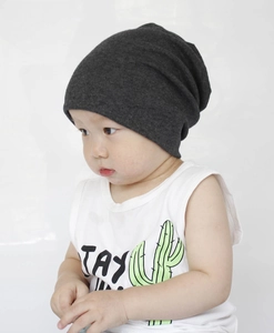 Detail shot of a dark grey knit beanie on a child, showing soft cotton texture and weave