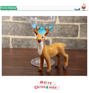 Close-up of a lifelike brown reindeer Christmas ornament with spotted fur on wooden surface