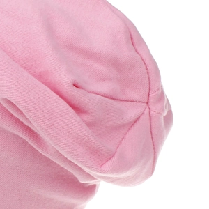 Close-up detail of soft pink cotton knitted fabric with high-quality stitching on the beanie