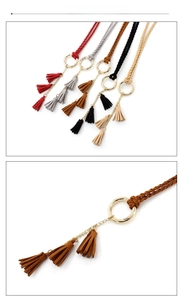 Detail of woven suede waist belts featuring golden rings and triple tassel charms