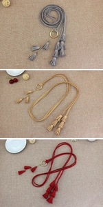 Detailed close-up of woven waist belts with golden metal rings and tiered tassel accents