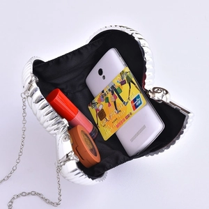 Silver shell-shaped evening clutch bag with chain strap and interior storage view