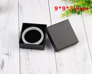 Macro view of square black textured jewelry box with white jade bangle 9x9x3.5cm