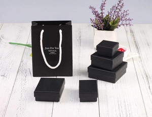 Matte black jewelry boxes and matching paper gift bags in various sizes with handles