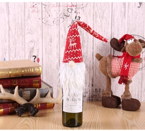 Detail of Christmas wine bottle cover with red gnome hat and white faux fur beard