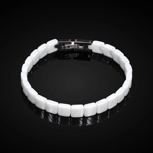 Modern 7mm black and white ceramic adjustable bracelet with metal clasp on black surface