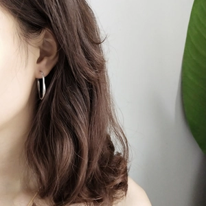 Detailed close-up of a 925 sterling silver hoop earring worn by a female model