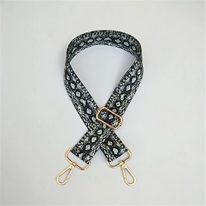 Detail of adjustable wide shoulder strap with snakeskin pattern and golden metal hooks
