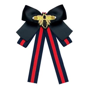 Detail of vintage bow brooch with gold bee embroidery and classic striped ribbons