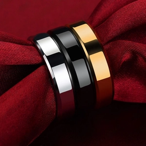 Detailed macro view of gold, silver, and black polished steel rings on red silk fabric
