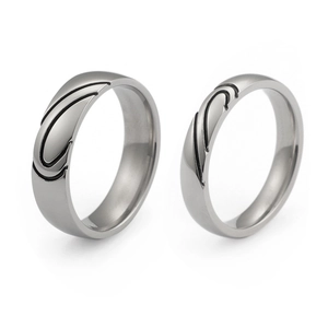 Polished titanium steel couple rings set with interlocking heart design on white background