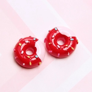 Detailed macro view of two red resin donuts with pink frosting and colorful sprinkles